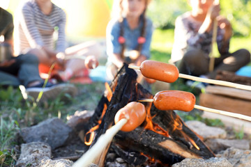 Wall Mural - frying sausages on bonfire, closeup. summer camp