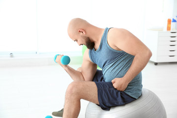 Sticker - Overweight man doing exercise with dumbbell in gym