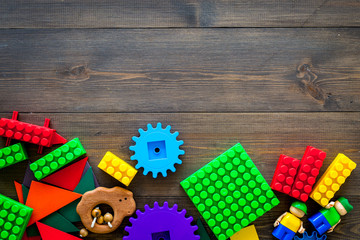 Educational toys for children mockup. Plastic blocks and clacks on dark wooden background top view space for text