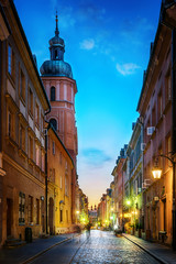 Wall Mural - Warsaw old town street. Evening view of old houses and Church. Long exposure. Warsaw, Poland.