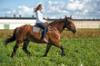 blonde riding a horse in a field