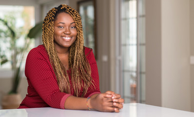 Sticker - African american woman sitting at home with a happy face standing and smiling with a confident smile showing teeth