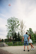 © Aleksandr - Young happy couple in love outdoors. Handsome man and beautiful woman on a walk in a spring blooming park. They let offhelium balls