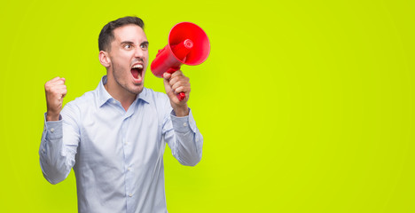 Poster - Handsome young man holding microphone annoyed and frustrated shouting with anger, crazy and yelling with raised hand, anger concept