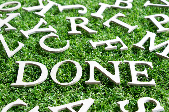 Wood alphabet in wording done  on artificial green grass background