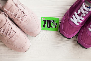 Various pairs of colorful sneakers laid on the white wooden floor background