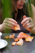 © Anna Jurkovska - Hands of a woman sitting at a table with rose petals