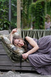 © Anna Jurkovska - Portrait of a woman lying on the sofa in a pavilion amidst mirrors and ornamental plants