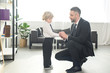 © LIGHTFIELD STUDIOS - smiling father fastening buttons on shirt sleeve of son