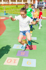 Canvas Print - Girl jumps by playing hopscotch