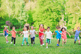 Fototapeta Las - Many different kids, boys and girls running in the park on sunny summer day in casual clothes