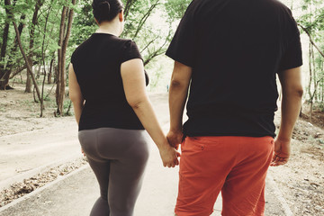 Wall Mural - Overweight couple walking together in park. Weight losing, outdoor activities, healthy lifestyle concept.