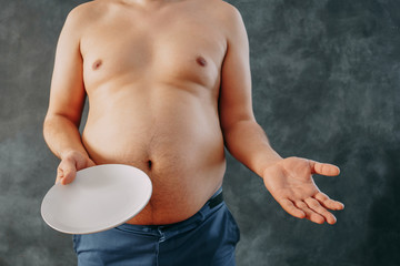 Wall Mural - Weight loss, anorexia, starving, overweight, dieting concept. Unknown man holding empty plate copy space