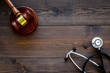 Medical law, health law concept. Gavel and stethoscope on dark wooden backgound top view copy space