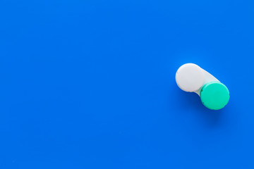 Contact lenses in container on blue background top view copy space