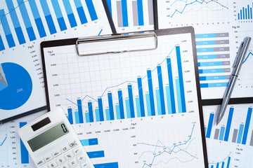 Poster - Financial reports. Analyzing and gathering statistical data. Many blue growth charts, calculator and pen.
