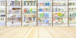 Pharmacy wood table counter with medicines healthcare product arranged on shelves in drugstore blurred defocused background