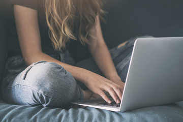 Young woman sitting and writing something on computer
