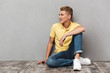 © Drobot Dean - Portrait of a smiling casual teenage boy with sitting