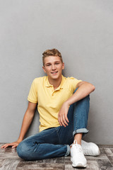 Canvas Print - Portrait of a smiling casual teenage boy with sitting