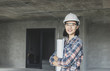 © khwanchai - portrait of engineering women holding blueprint at construction site