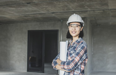 portrait of engineering women holding blueprint at construction site