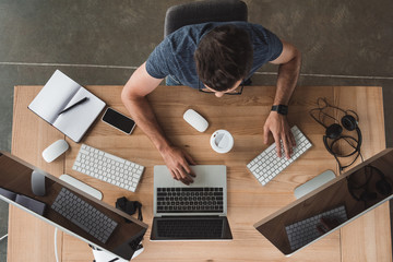 overhead view of programmer using computers at workplace