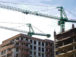 Construction site background. Two cranes near building under construction