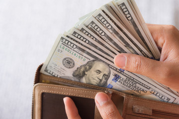 Wall Mural - Close up Woman Hands taking out money America dollars banknotes from wallet.