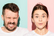 © master1305 - Closeup portrait of young couple, man, woman. One being excited happy smiling, other serious, concerned, unhappy on pink and blue background. Emotion contrasts