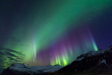 northern lights above snowy mountains on iceland