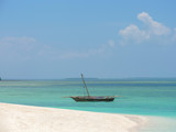 Fototapeta Tulipany - Fisherman fishing and sails on a wooden boat on clear blue water along a tropical exotic beach in Africa. Indian Ocean, Zanzibar