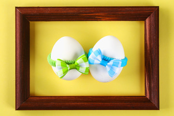 The concept for the international friendship day. Eggs in bows on a yellow pastel background.