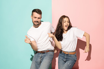 a couple of young man and woman dancing hip-hop at studio.