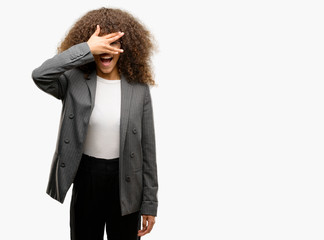 Canvas Print - African american business woman wearing glasses peeking in shock covering face and eyes with hand, looking through fingers with embarrassed expression.