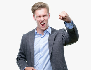 Poster - Young handsome blond business man angry and mad raising fist frustrated and furious while shouting with anger. Rage and aggressive concept.