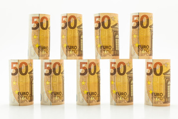 Rolled up 50 euro banknotes in rows. Isolated on a white background.