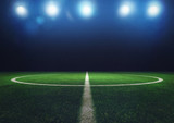 Fototapeta Sport - Midfield of grass soccer field at night with headlights