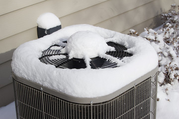 Home air conditioner unit covered with snow in winter