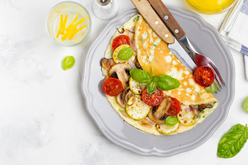 Wall Mural - Thin rolled omelet with fried vegetables, zucchini, tomato, onion, mushrooms, tasty healthy Breakfast,