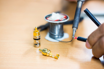 Closeup of soldering RCA cable, Repair and adjustment of the equipment, the RCA cable and pliers on the table