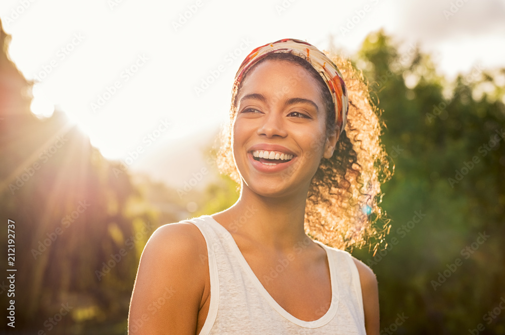 Young african woman smiling at sunset - obrazy, fototapety, plakaty 