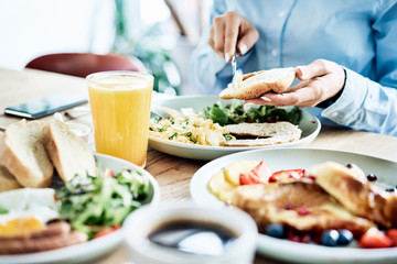 woman having delicious and healthy breakfast in restaurant. close up of nutritious food