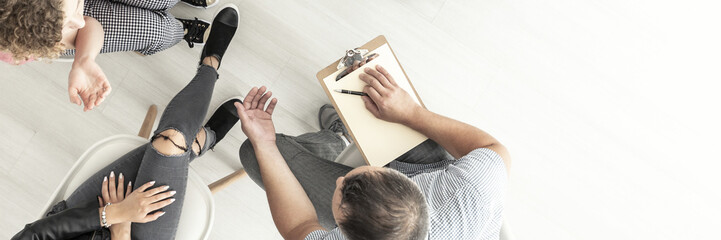 Canvas Print - Top view of psychologist talking with difficult young people about problems