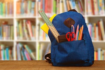 Poster - Composite image of bag with school supplies on wooden table