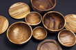 Wooden utensils for the kitchen, bowls, plates on a black background. The concept of natural dishes, a healthy lifestyle. Texture of wood. Wooden eco-ware
