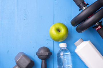 Fitness equipment and Health food on blue wooden background