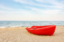 Old Red Boat On The Beach, Waves On The Water And Clouds Background
