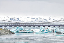 Jokulsarlon Glacial Lagoon, Glacial Lake In Iceland With Many Icebergs Floating, Route One 1 Bridge Over Water With People, Vatnajokull Mountains, Cliffs, Snow, Clouds