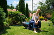 Gardener girl is cutting the grass with the mower
